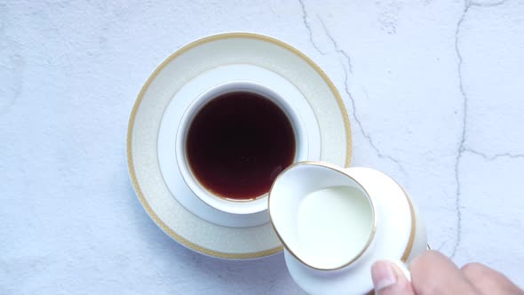 Milk Poured Into a Cup of Tea Top View