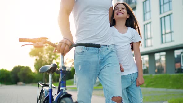 Dad and Daughter Walk Around Their Area After Cycling at Sunset
