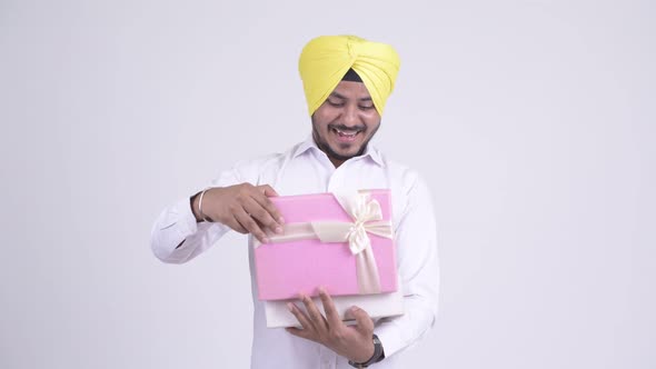 Happy Bearded Indian Sikh Businessman Opening Gift Box