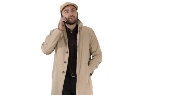 Man dressed in trench making business call while walking