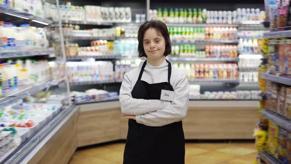 Portrait of a Shop Worker with Down Syndrome Standing with Crossed Hands at Supermarket