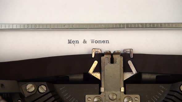 Typing phrase Men and Women on retro typewriter. Close up.