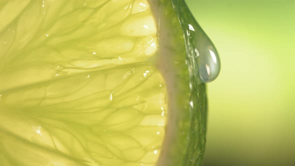 Drop of Water Flows Down the Surface of a Ripe Juicy Lime Slice