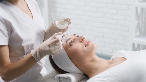 Beautician Doing Cleaning Face with Cosmetics for Patient