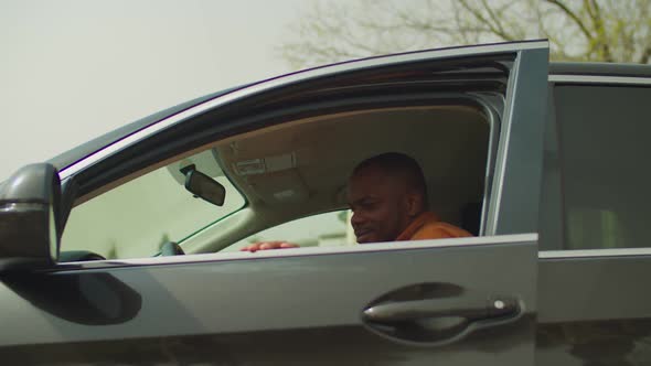 Positive Black Man in Driver's Seat Smiling in Car