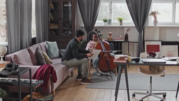 Tutor Helping Girl Play Double Bass