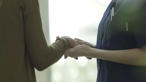 Nurse comforting patient, cropped