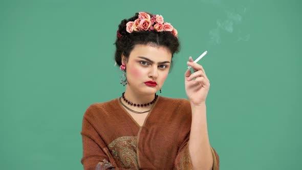 Portrait of Elegant Woman with Thick Eyebrows As Frida Kahlo with Roses in Hair Looking Seriously