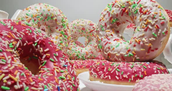 Colorful donuts with sprinkles. White and pink donuts with glaze.