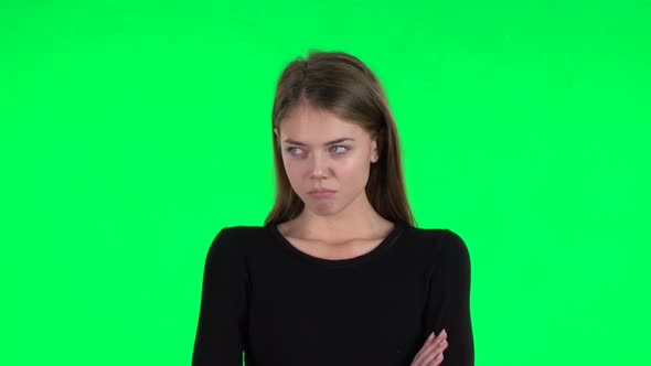 Young Woman Stands Offended and Then Smiles. Green Screen