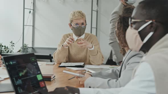 Confident Businesswoman in Face Mask Talking to Colleagues