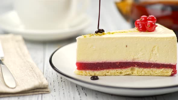 Redcurrant Cheesecake on a Plate Decorated with the Red Berries Being Poured with Chocolate Glaze