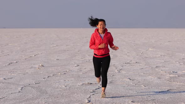 Asian woman jogging across the Bonneville Salt Flats flats