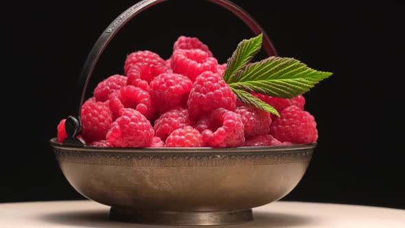 Ripe Raspberries in Vintage Metal Bowl Rotation on Black Background