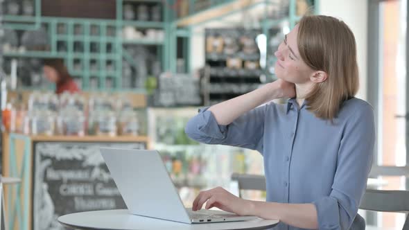 Young Woman Having Neck Pain While Typing on Laptop