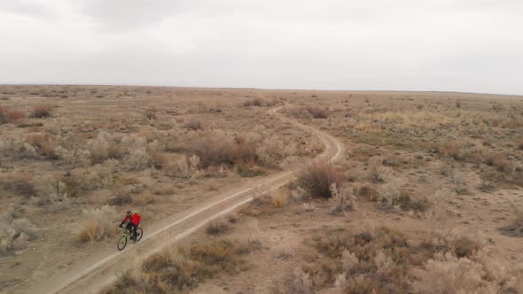 Drone Shot of Bicyclist Ride in the Desert in Kazakhstan