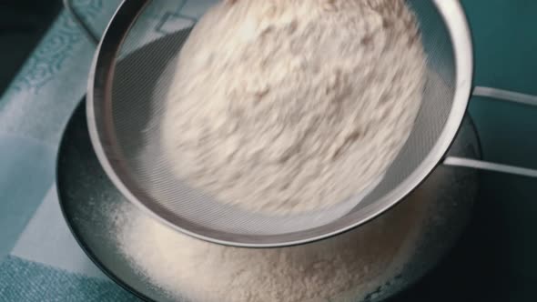 Young Girl Sifts Flour Through a Sieve Into a Baking Dish Closeup View