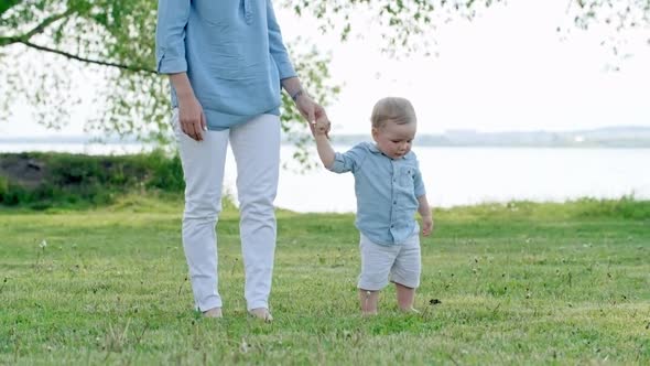 Mother and Little Boy Walking in Park alt