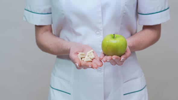 Nutritionist Doctor Healthy Lifestyle Concept - Holding Green Apple and Medicine or Vitamin Pills