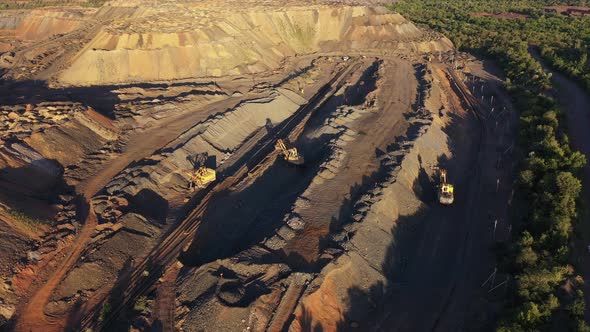 Heavy Mining Machinery in a Open Quarry Aerial Evening View