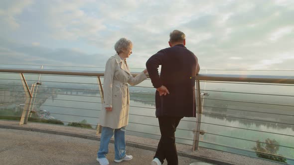 Senior Couple Meeting Dawn of the Sun Standing on a Terrace