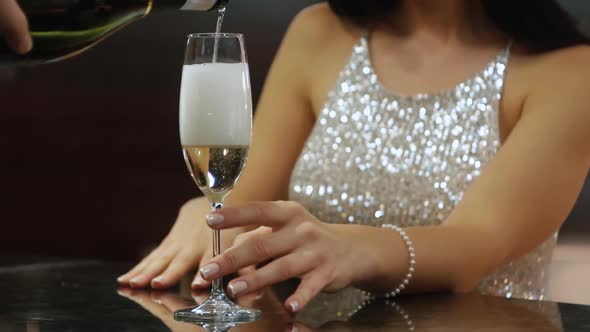 Unrecognizable Woman in a Brilliant Dress at the Bar