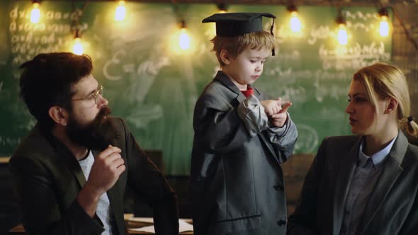 Father Mother and Son at School. Schoolboy Studying Homework During Her Lesson in Class.