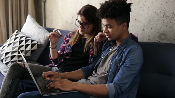 Young Happy Couple of Two Hipsters Ordering Food Online Using Laptop