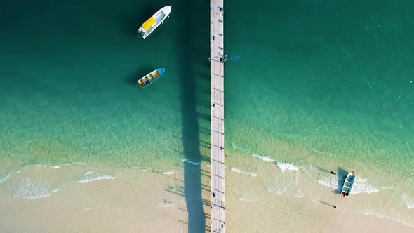 Aerial of white sand beach with wooden pier on 4k Beach, Koh Rong, Cambodia