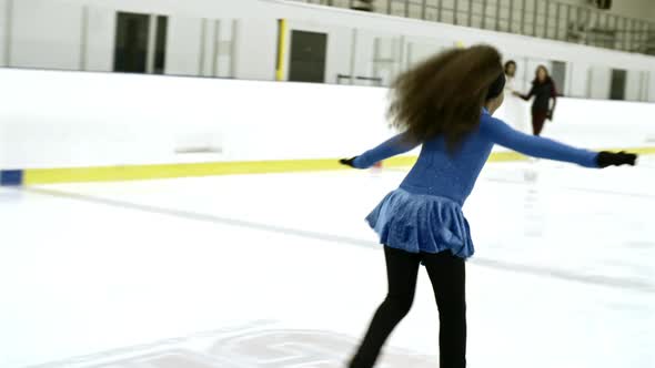 Girl in Blue Dress Practicing Ice Skating