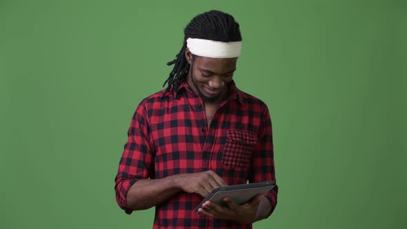 Young Handsome African Man with Dreadlocks Against Green Background