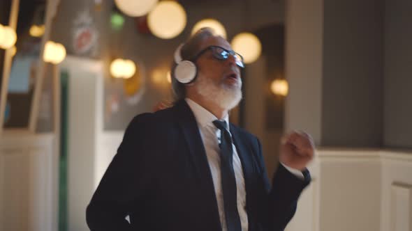 Happy Mature Businessman with Headphones Dancing Celebrating Success