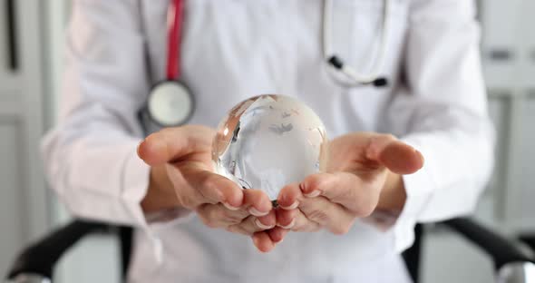 Doctor Holding Glass Globe with World Map  Movie Slow Motion