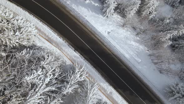 Aerial View of Winter Landscape with Snow Covered Mountain Woods and Winding Forest Slippery Road