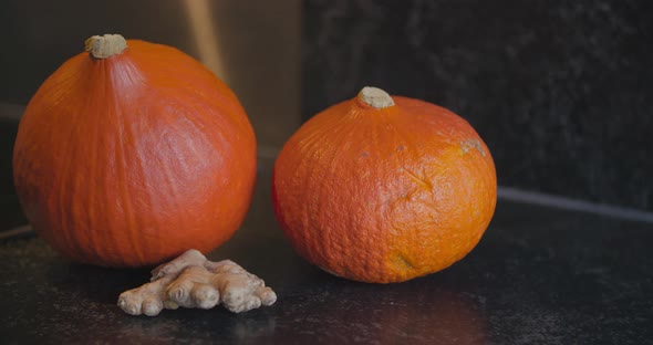 two orange pumpkins and ginger ready to be used for soup ingredients or halloween decoration