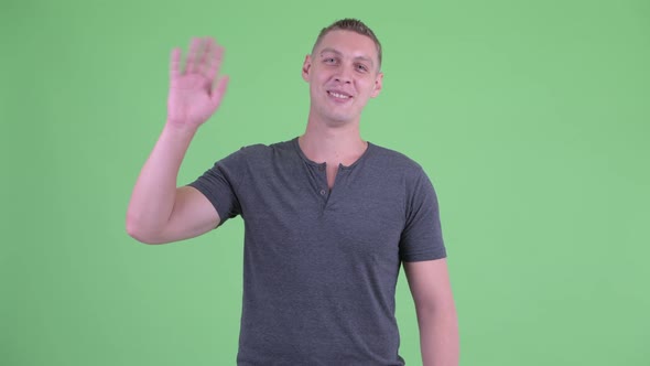 Portrait of Happy Young Man Waving Hand