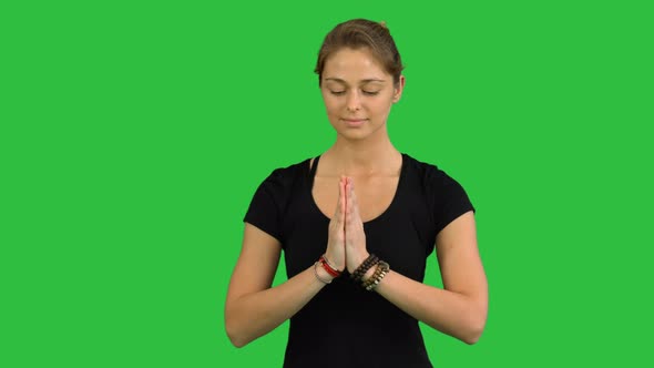 Woman with Namaste Mudra Gesture Meditating with Closed Eyes on a Green Screen, Chroma Key