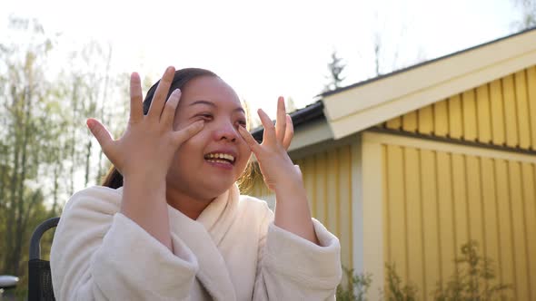 close up Asian woman sitting on a chair outside home and laughing with friend in the morning