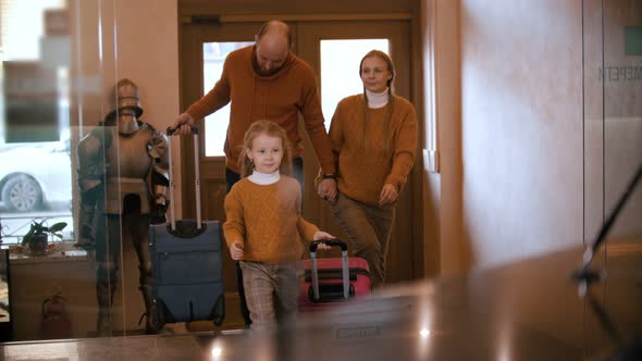 A Happy Family in Similar Clothes Entering the Luxury Hotel