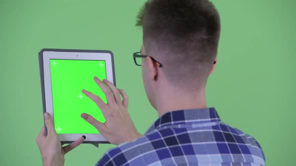 Closeup Rear View of Young Hipster Man Using Digital Tablet