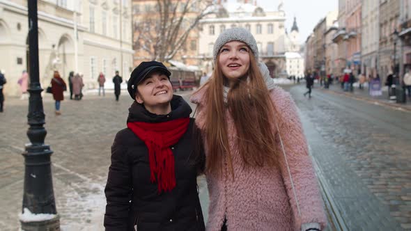 Women Tourists Taking Selfie Photos on Mobile Phone with Adoption Child Girl on Winter City Street