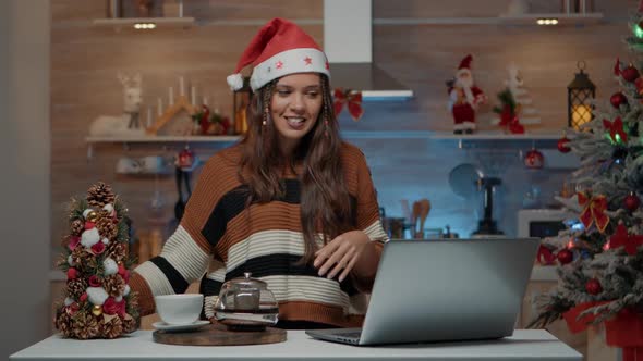 Festive Woman Using Laptop for Video Call on Christmas Eve
