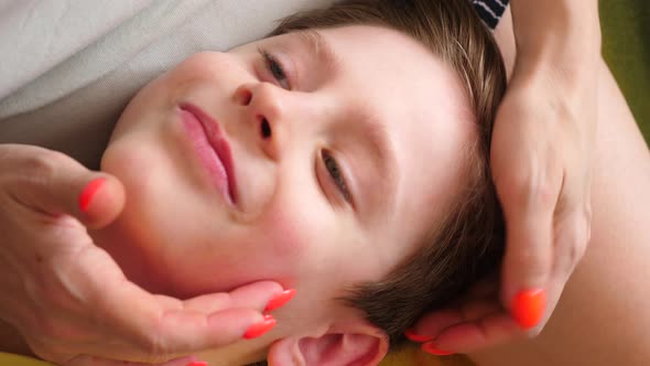  Caucasian happy boy 7 years old lies on his mother's lap, mother strokes her son's hair. slow motio