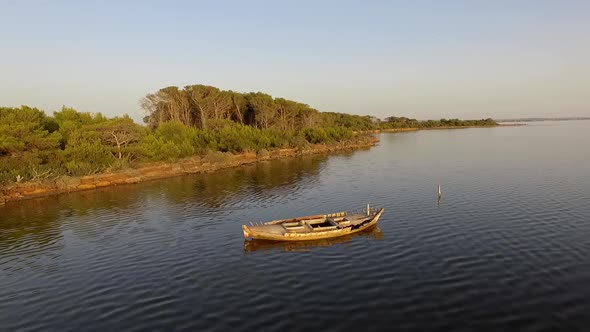 Aerial view of a lake and old boat at sunset.