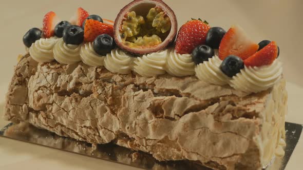 Dessert Roll of Meringue with Butter Cream Decorated with Fruits and Berries Rotates Slowly