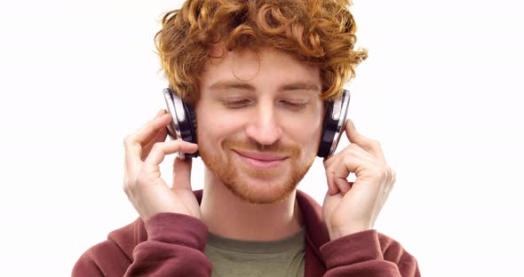 Beautiful Happy Fun Young Adult Redhead Man Listening to Music Using Headphones and Dancing