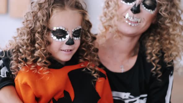 Mother and Daughter with Curly Hair Wearing Halloween Costumes