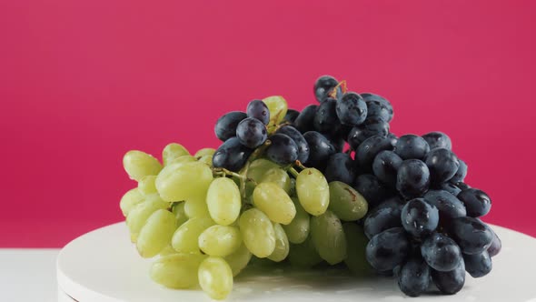 Close Up of Black and White Grapes on Rotating Table Isolated on Background