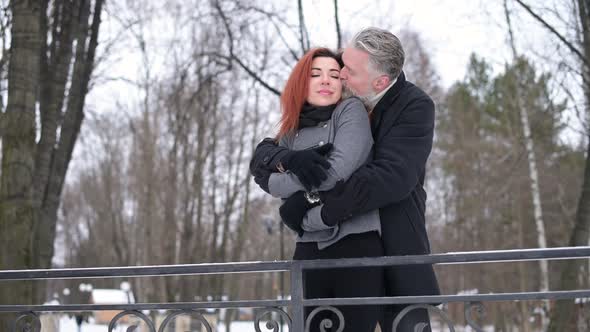 Two lovers in the park, husband and wife - gray-haired man and a young woman