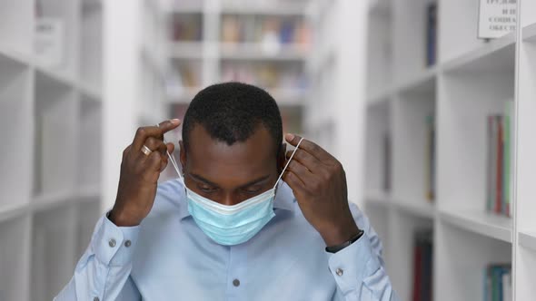 University Library: African American Man in a Mask During Quarantine Covid-19 Prepares for the Exam